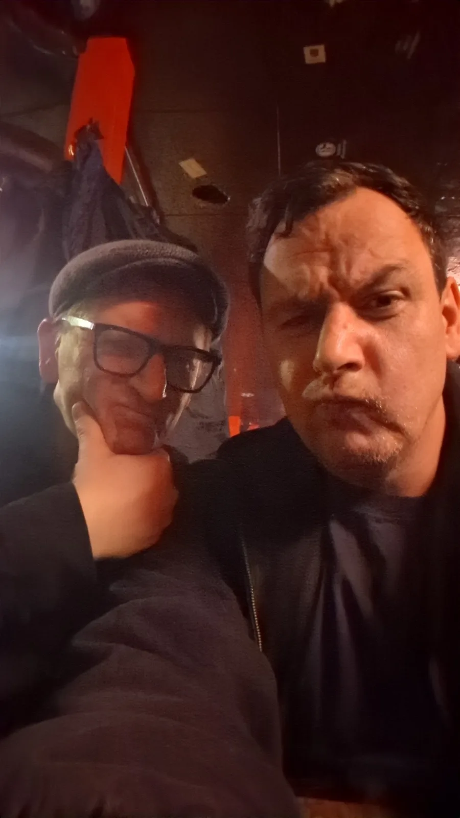 Selfie von zwei Männern in einem dunklen Raum