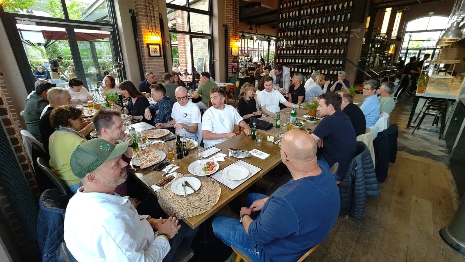 Lange Tafel in einem Restaurant, viele Gäste beim Essen
