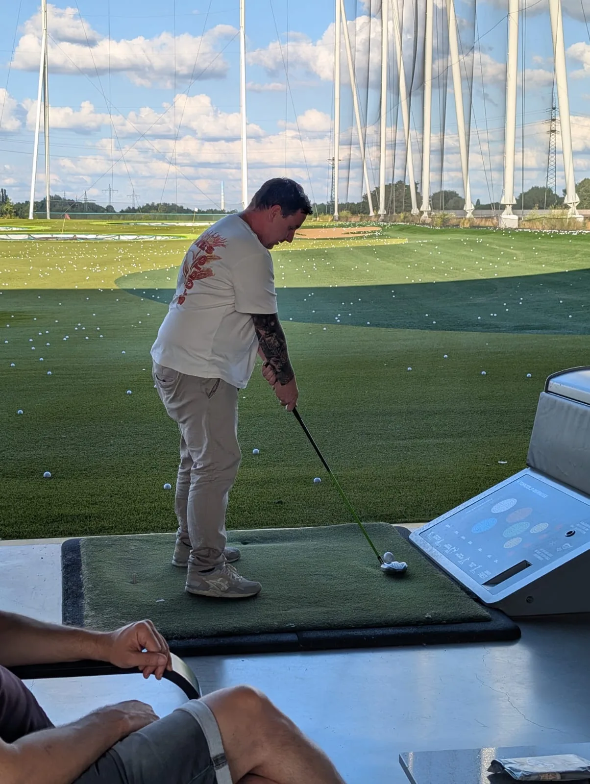 Mann beim Abschlag auf einer Driving Range