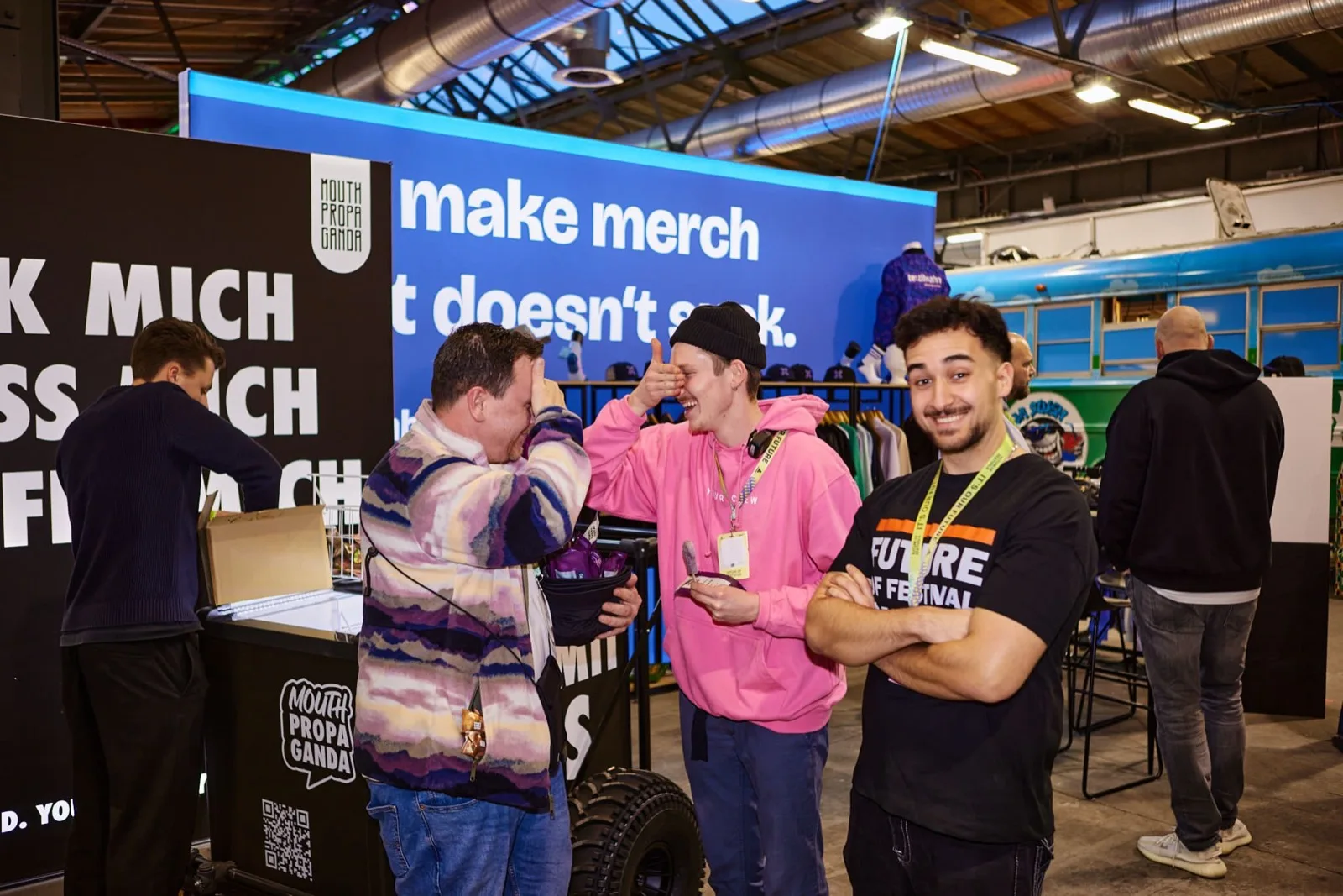 Messestand mit blauer Rückwand, davor vier Personen im Gespräch