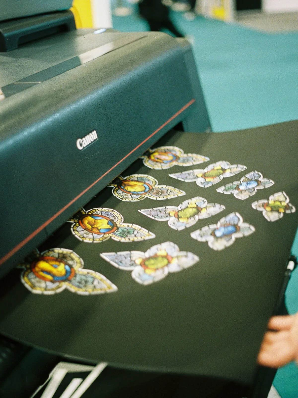 Zugeschnittene Transferfolien mit bunten Motiven auf einer Arbeitsflaeche