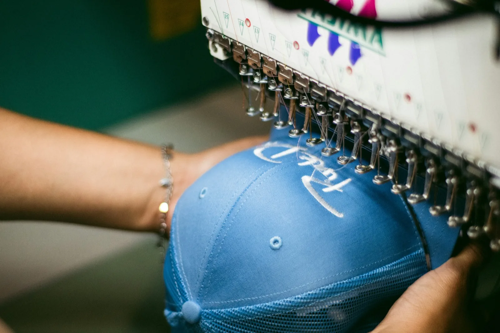 Stickmaschine bestickt eine blaue Cap