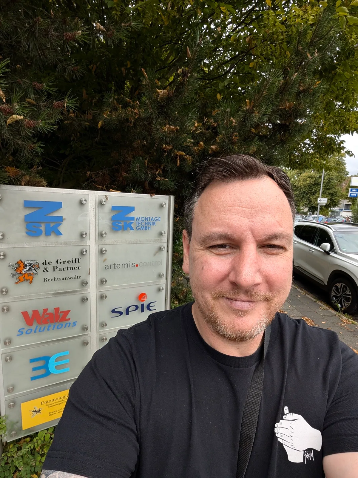 Selfie vor dem Firmenschild eines Gewerbehofs