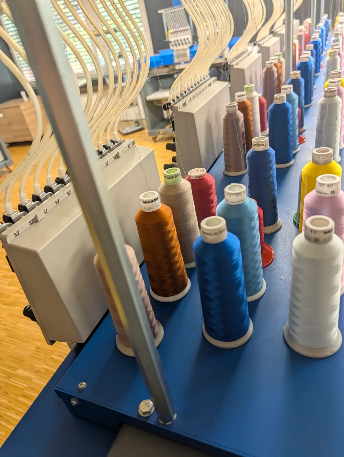 Farbreihe aufgesteckter Stickgarne an der Maschine