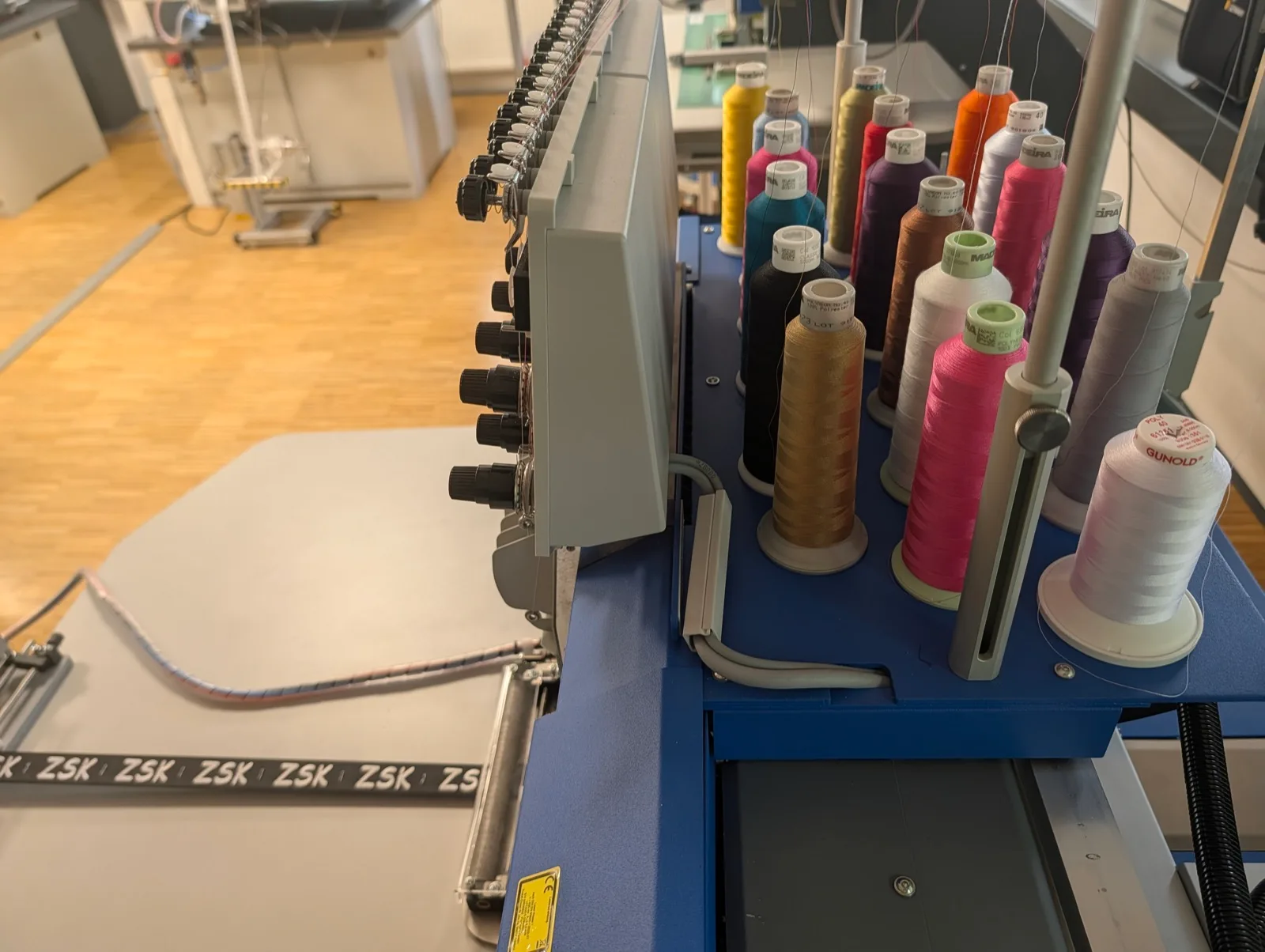 Stickkopf mit aufgesteckten Garnkonen im Hintergrund