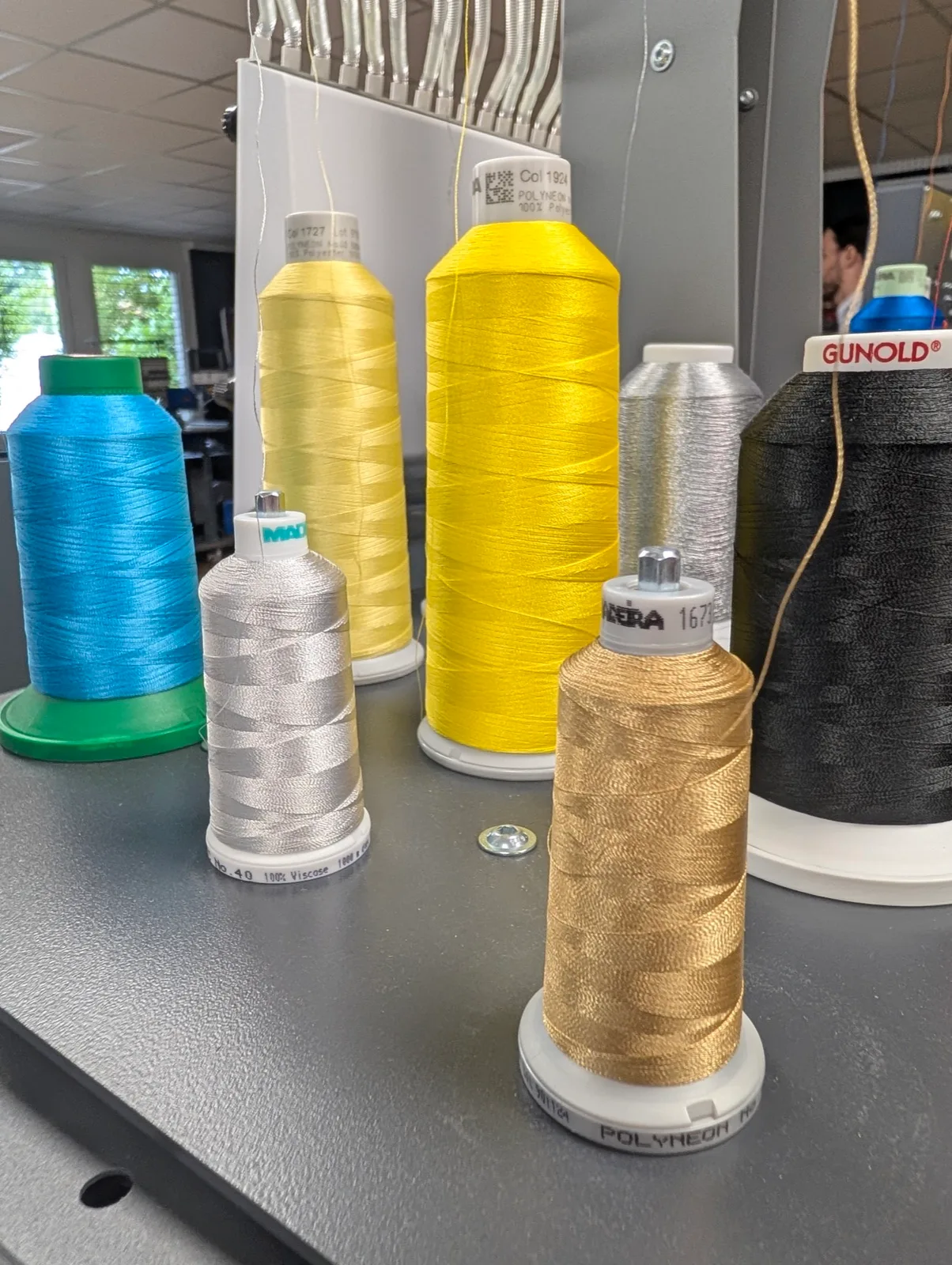 Stickgarnkonen in Gold, Silber und Schwarz auf der Werkbank